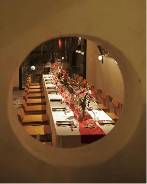 Elegant long dining table setup viewed through a circular opening.
